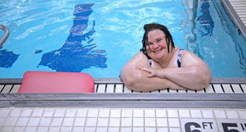 A person in the pool smiling at the camera.