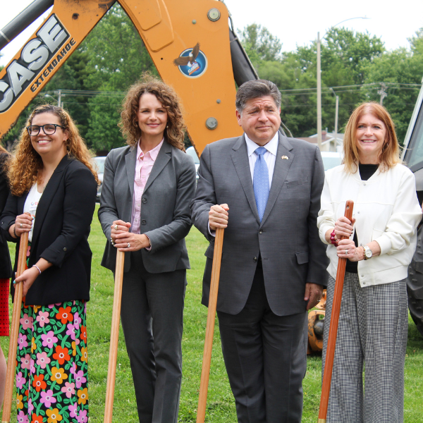 4 adults hold shovels in a special groundbreaking ceremony.